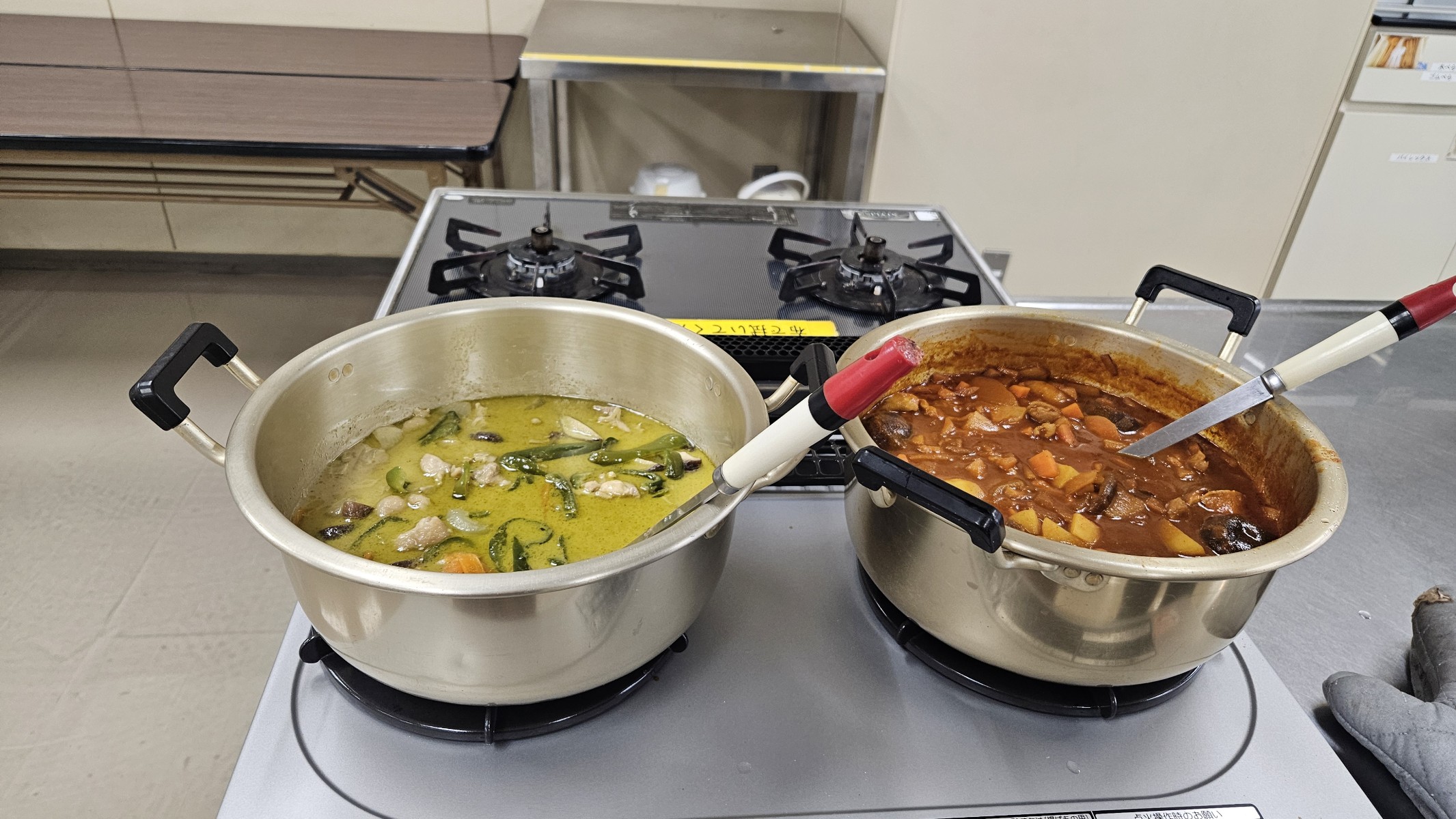 二つの鍋。左が緑のグリーンカレー、右が赤いスパイスカレー
